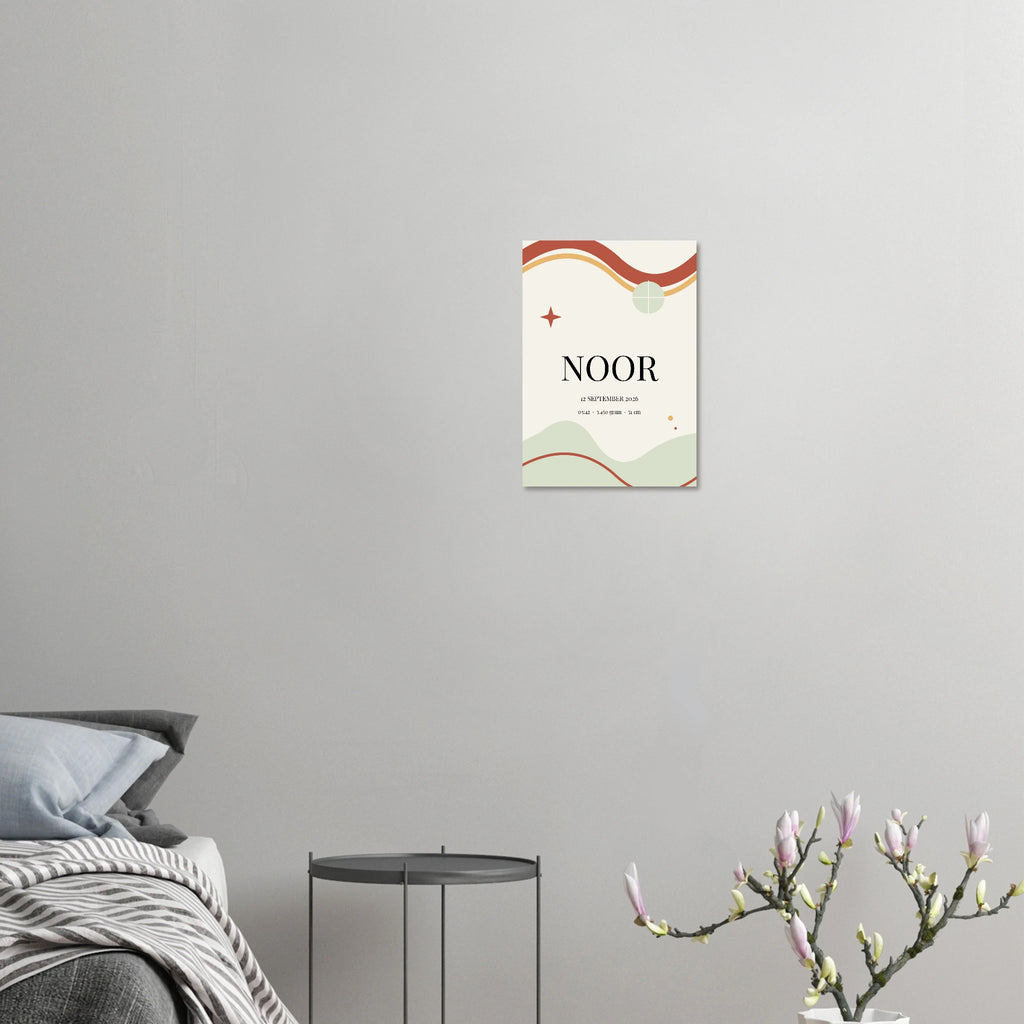 Geboorteposter Momentbogen met voorbeeldnaam Noor aan een grijze muur naast een bed